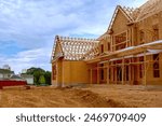 Newly constructed house with unfinished interior with wooden stud timber framing supports beams