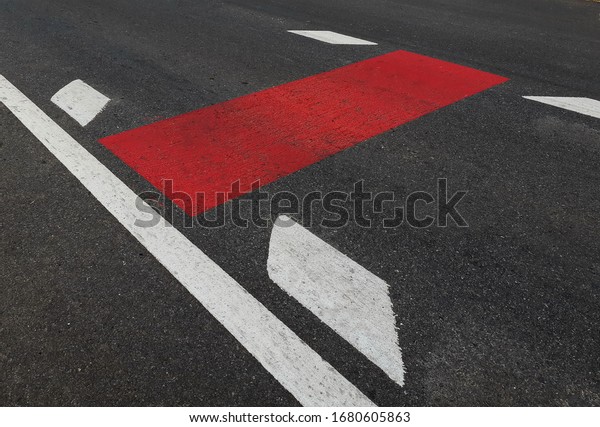 Newly constructed roads marked,\
with white lines and red stripes and arrows, rural\
Thailand