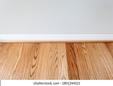 Newly Installed Red Oak Floor Boards With Trim Protection For Wall