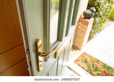 Newly installed, uPVC front door showing the brass fittings. Also in view are the multiple bolts used to secure the door by lifting up the door handle.