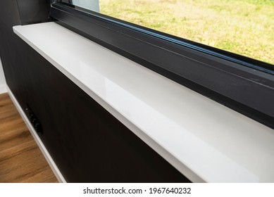 Newly installed white conglomerate window sill inside the room, on the black wall. - Shutterstock ID 1967640232