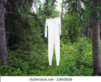 Newly Laundered White Long Johns Union Jack Underwear Hanging From Clothespins On Clothesline Between Trees In Forest