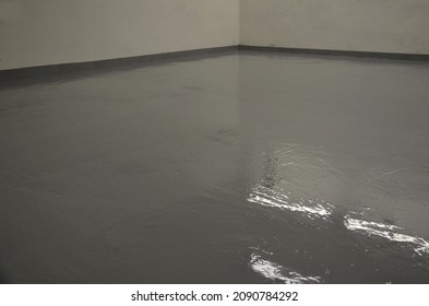 Newly Painted Garage Floor With Gray Latex Paint. The Surface Is Glossy And Easy To Maintain And Wash. Resistant To Oil And Chemicals. It Looks Wet And Shines