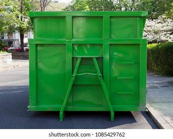 Newly Painted Green Industrial Dumpster Container On Neighborhood Street. Isolated.