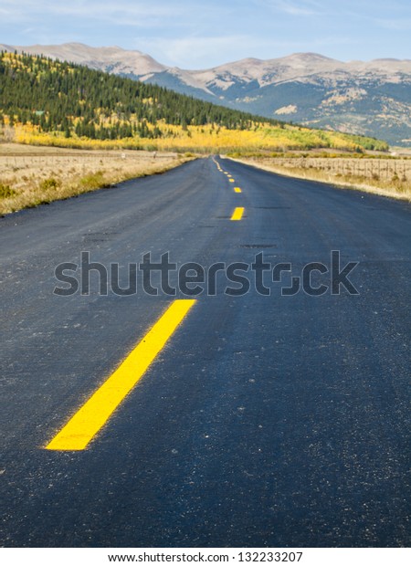 Newly paved road on\
autumn day in Colorado.