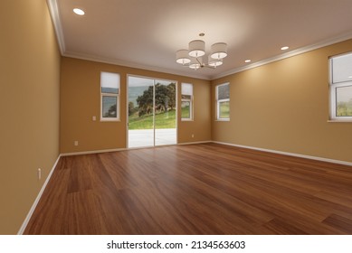 Newly Remodeled Room of House with Finished Wood Floors, Moulding, Dark Tan Paint and Ceiling Lights. - Shutterstock ID 2134563603