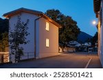 Newly renovated house, with modern finishes, night scene. Next to the house is the main road of the small village in Switzerland. Nobody inside