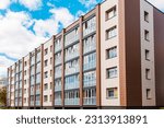 A newly renovated residential building apartments.Gray,brown block of flats.Newly finished modern style apartment building in freshly renovated residential area.Sunny summer day.