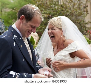 A Newly Wed Bride And Groom Covered In Confetti