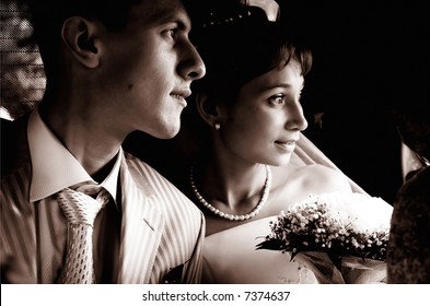 Newly wedded staring into the future from the car