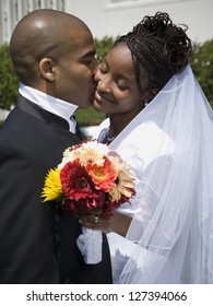 Newlywed african american couple kissing and smiling