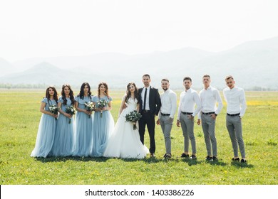 Newlywed Couple, Bridesmaids & Groomsmen Having Fun Outdoors