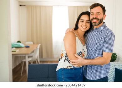 Newlywed couple embracing in their modern living room, excited to begin their family journey in their comfortable home - Powered by Shutterstock