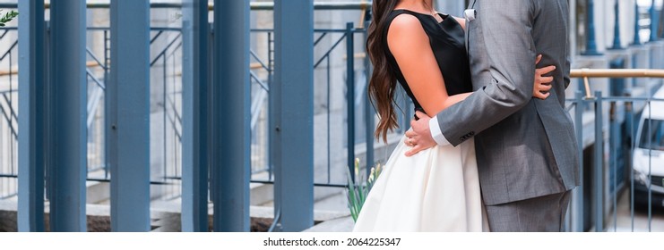 Newlyweds Couple Hugging On The City Street. Middle Section Two People Embracing. Bride And Groom Close In Elegant Formal Wear. Copy Space