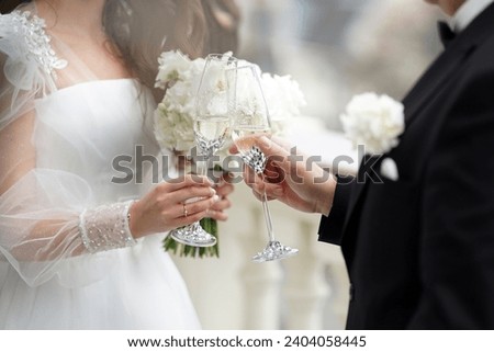 The newlyweds raise a celebratory toast with glasses of white champagne. Wedding celebration.