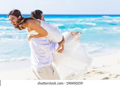 Newlyweds sharing a romantic and fun moment at the beach