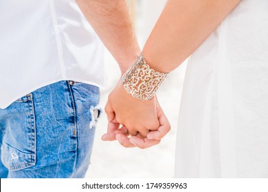 Newlyweds At The Wedding Romantic Couple Holding Hands During Destination Wedding Marriage Matrimonial Ceremony On The Sandy Beach In Dominican Republic, Punta Cana. Family, Love, Unity Concept.  