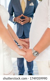 Newlyweds At The Wedding Romantic Couple Holding Hands During Destination Wedding Marriage Matrimonial Ceremony On The Sandy Beach In Dominican Republic, Punta Cana. Family, Love, Unity Concept.  