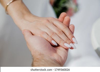 Newlyweds At The Wedding Romantic Couple Holding Hands During Destination Wedding Marriage Matrimonial Ceremony On The Sandy Beach In Dominican Republic, Punta Cana. Family, Love, Unity Concept.  