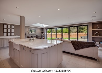 Newmarket, Suffolk - April 29 2016:  Modern Open Plan Kitchen Family Room With Island Peninsular Cabinets And Bifold Doors Leading To Garden.