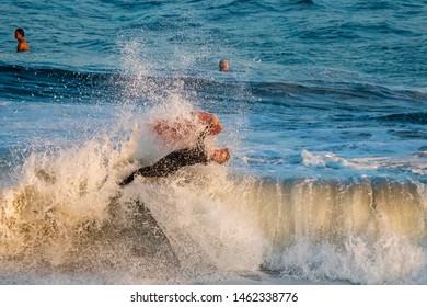 Newport Beach, CA / USA - July 5, 2018: A body boarder surfs a large wave at The Wedge in Newport Beach, California during sunset 
