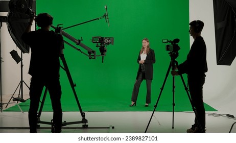 News anchor at work, woman journalist presenter telling weather news, view of a backstage studio TV news shooting, chroma key template. - Powered by Shutterstock