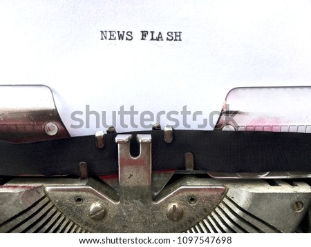NEWS FLASH, title heading typed in black ink on white paper on vintage retro manual typewriter machine