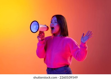 News  information  Young girl in pink sweater talking in megaphone over gradient orange background in neon light  Concept emotions  facial expression  youth  lifestyle  inspiration  sales  ad