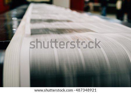 Newspaper being printed on rolls of paper 