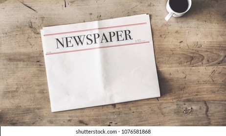 Newspaper and coffee on wooden background