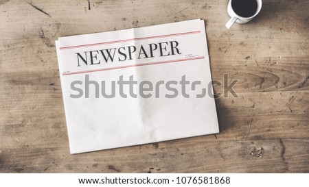 Newspaper and coffee on wooden background