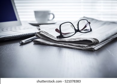 Newspaper with computer on table - Shutterstock ID 521078383