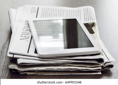 Newspaper And Digital Tablet On Wooden Table