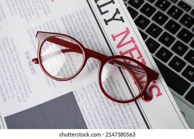 Newspaper And Glasses On Laptop, Top View