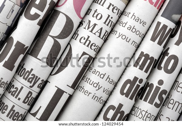Newspaper headlines shown side on in a stack\
of daily newspapers