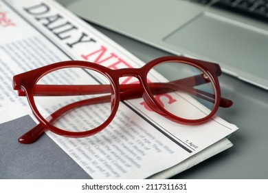 Newspaper, Laptop And Glasses On Grey Table, Closeup