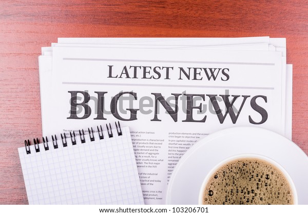 The newspaper LATEST NEWS with the headline BIG\
NEWS  and coffee