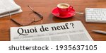 A newspaper on a wooden desk - Whats new in french - Quoi de neuf