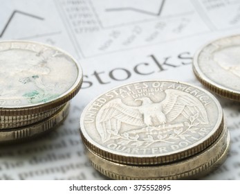 Newspaper open to stock market page showing word "Stocks" and coins. Concept of Investment.