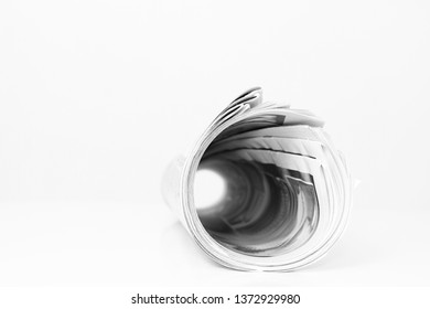 Newspaper Rolled Up And Sitting On A Table No People Stock Photo