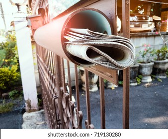 The Newspaper Rolls In The Box At The Front Fence With Lens Flare.