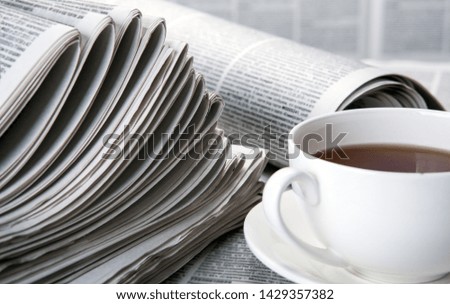 newspapers and a cup of coffee on the table closeup