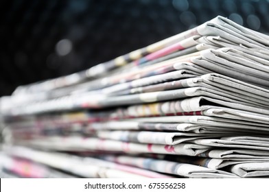 Newspapers Folded And Stacked On The Table Modern Dark Background. Closeup Newspaper And Selective Focus Image.