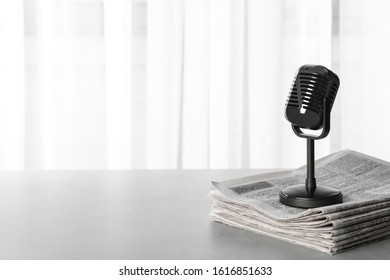 Newspapers and vintage microphone on grey table, space for text. Journalist's work - Shutterstock ID 1616851633