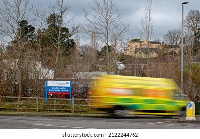 Newton Abbot, Devon, England. 02 12 2022. An Ambulance Rushes Into Hospital. The Ambulance Has Motion Blur As It Speeds Onto The Hospital Grounds. Yellow Emergency Vehicle With A Patient In Care. 