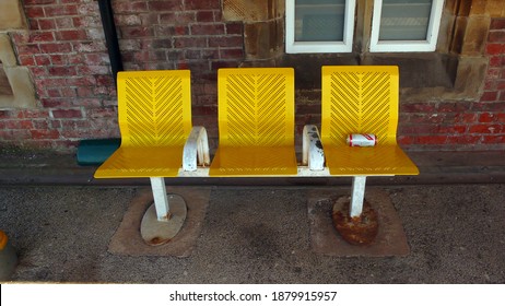 NEWTON Le WILLOWS.  MERSEYSIDE. ENGLAND. 13-04-19.
The Railway Station On The Historic Liverpool To Manchester Route. A Row Of Three Platform Seats And An Empty Beer Can.