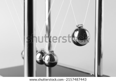 Newton's cradle on light background, closeup. Physics law of energy conservation