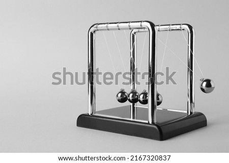 Newton's cradle on light background, space for text. Physics law of energy conservation
