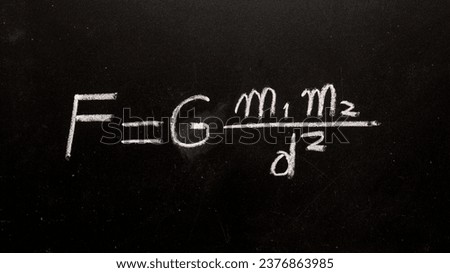 Newton's law of gravity formula handwritten on a blackboard with chalk