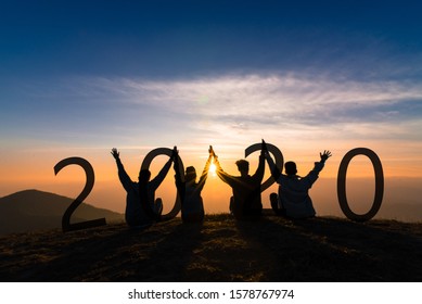 Newyear 2020 Concept Silhouette Of Young Friend Jumping And Hand Shake For Celebrate New Year Party.